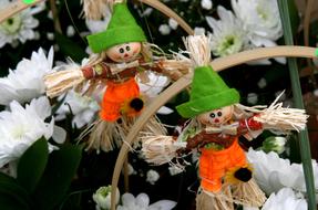 Beautiful and colorful, cute scarecrow figures, among the colorful flowers in the spring