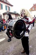 man in a mask with a drum