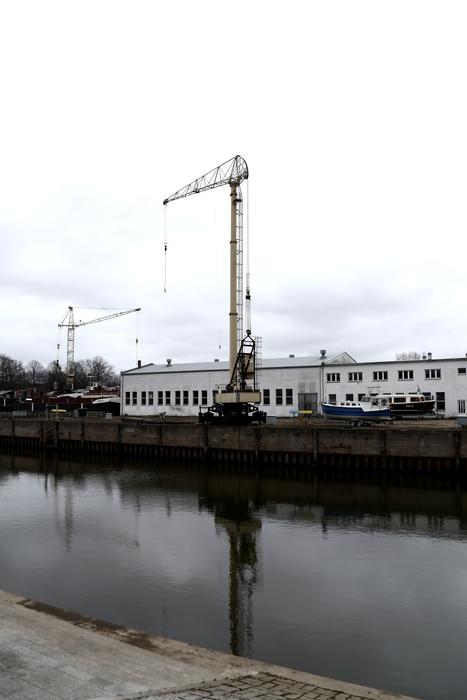 port cranes on the bank of the city river