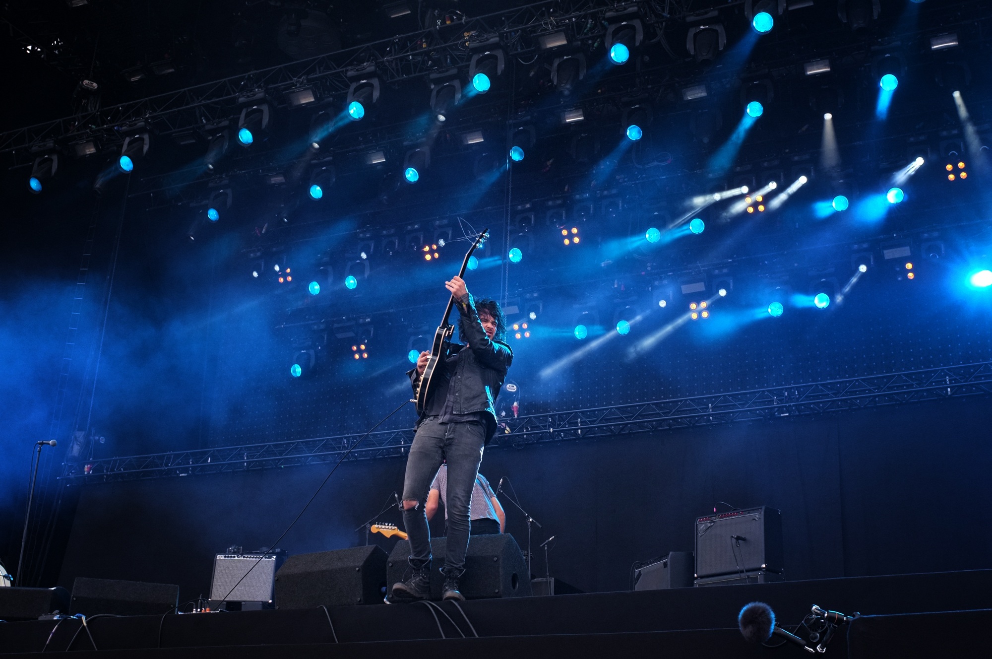 Bright musician standing on stage in lights free image download