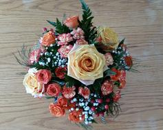 Beautiful bouquet with the colorful and beautiful, different flowers and leaves, on the wooden surface