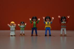 Toy figures of people raising their hands up