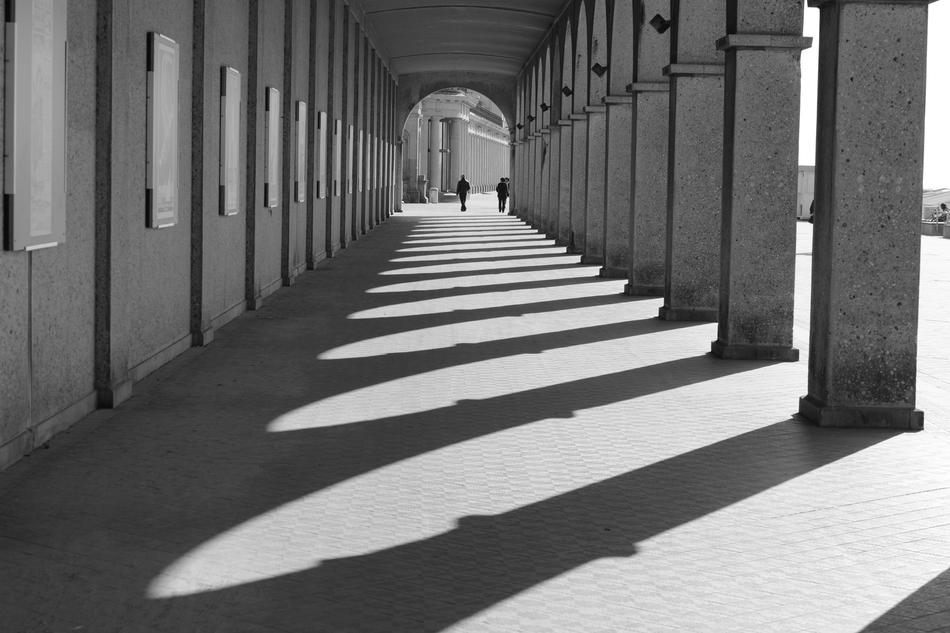 man walking in the distance through an archway