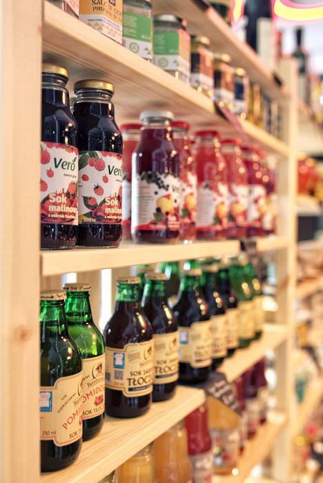 glass bottles with juice on the shelves in the supermarket