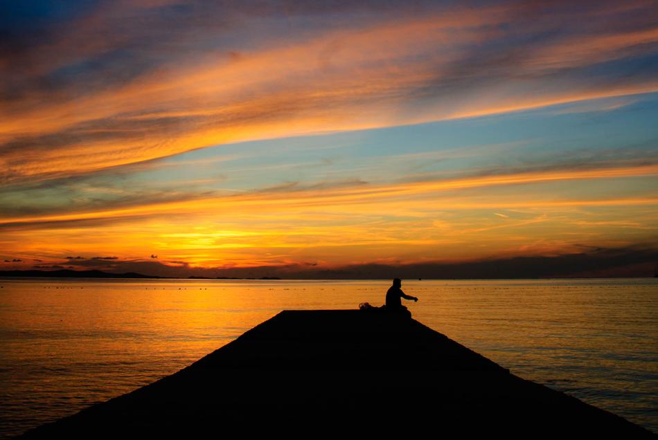 evening, a man is resting on the pier
