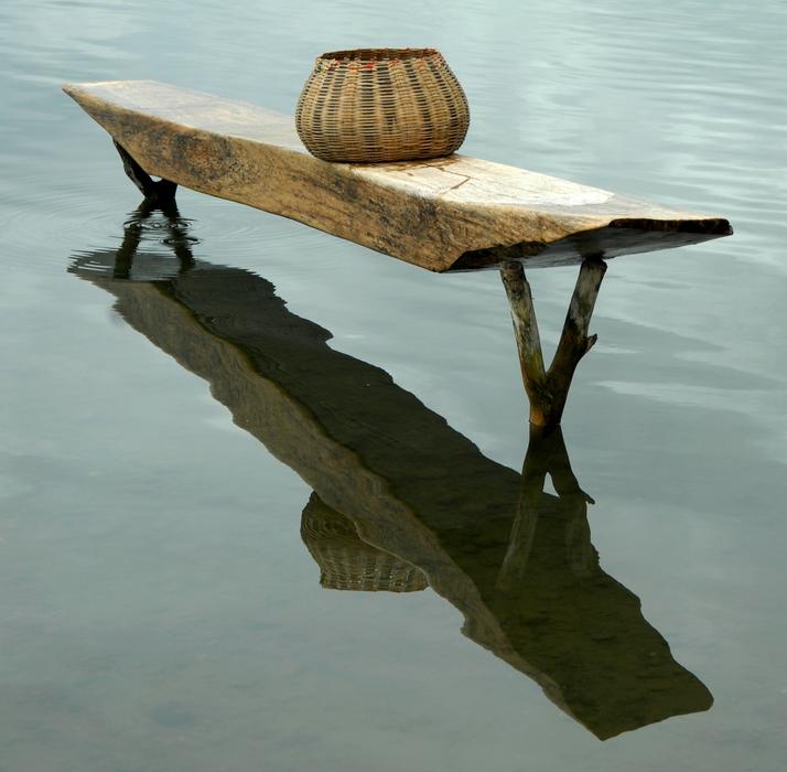 bench with a pitcher on the water
