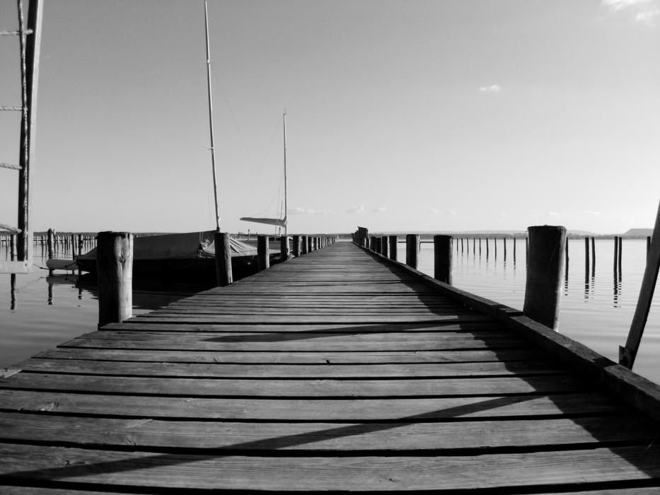 Wooden pier with boats on the side