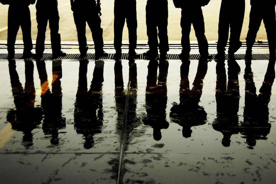 Silhouettes of a man's legs reflecting in a puddle