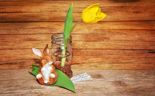 easter background, bunny figurine and Tulip in vase at wood