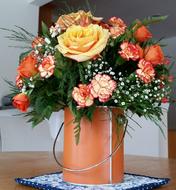 a bouquet of roses in a metal bucket