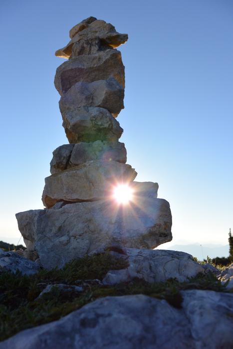 Stones built into a tower in front of the sun