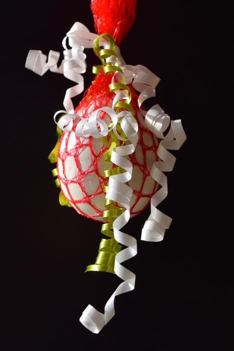 Egg decorated with red net and ribbons