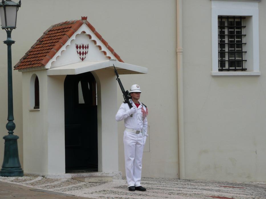 man guarding a house with a gun on his shoulder