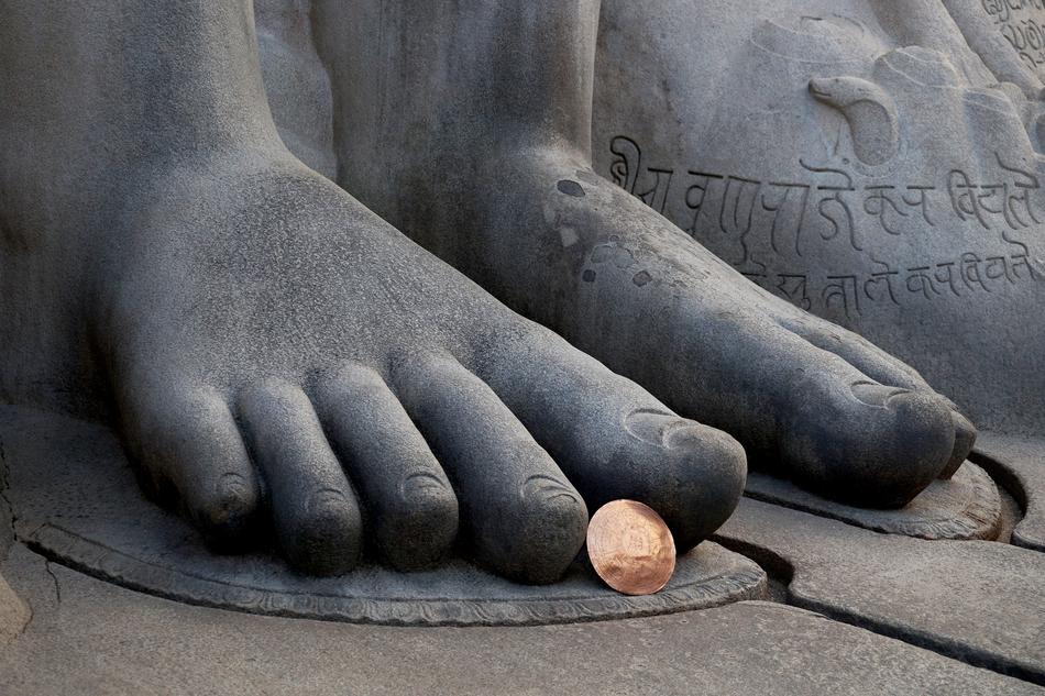 coin lying under the statue finger