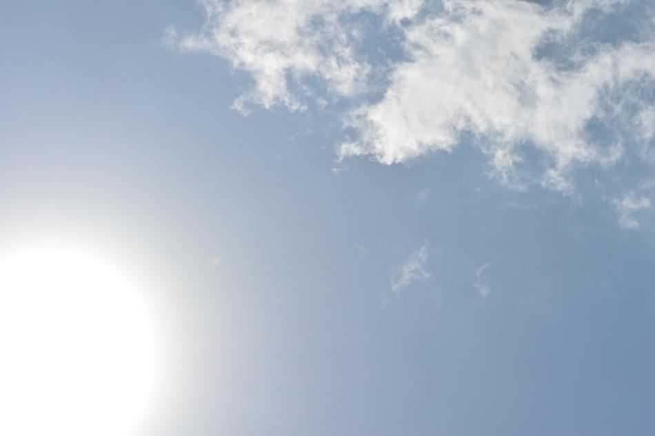 Bright sun in a blue sky with clouds