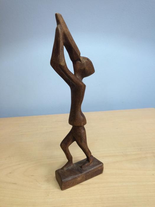 Wooden figurine of a man with a container in his hands