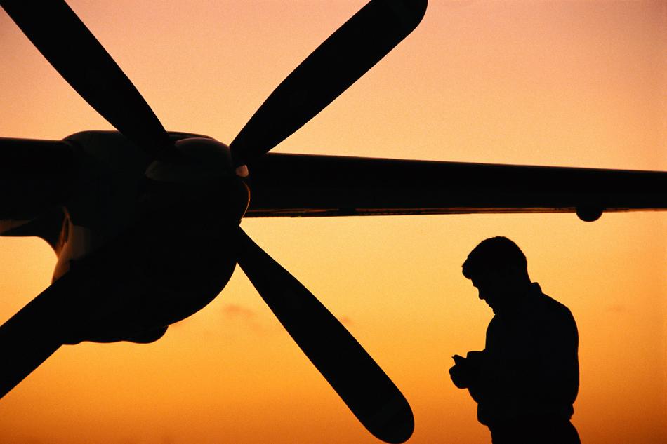 silhouette of a man in front of a helicopter