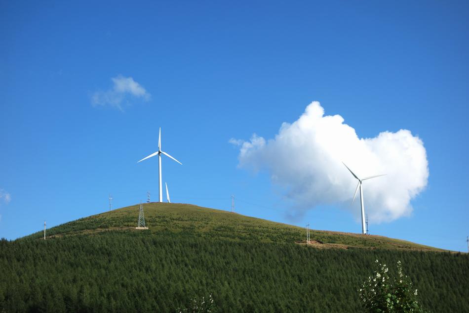 Windmill on green hills scenery