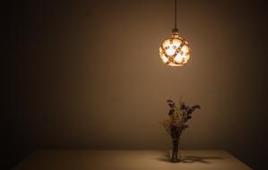 Beautiful glowing lamp above the decoration with flowers on the table