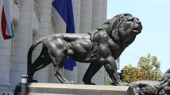 iron sculpture of a lion in front of the building