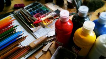 colored paints and pencils on the table