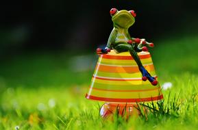 frog sitting on a lamp in the grass