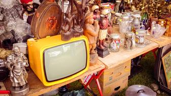 yellow television with figures on the table
