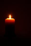 burning orange candle in the night
