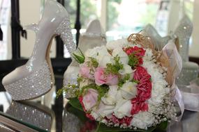 wedding bouquet near white shiny shoes