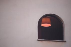 window with a burning lamp in the room