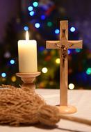 wax candle with a wooden cross on the table