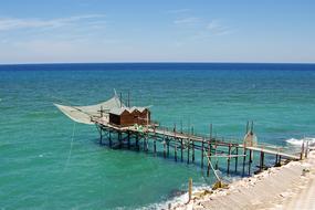 long bridge with a house by the sea