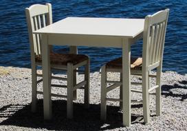 white table and chair near the sea