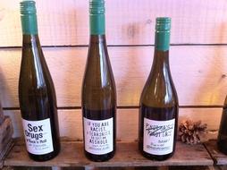wine glass bottles against a wooden wall