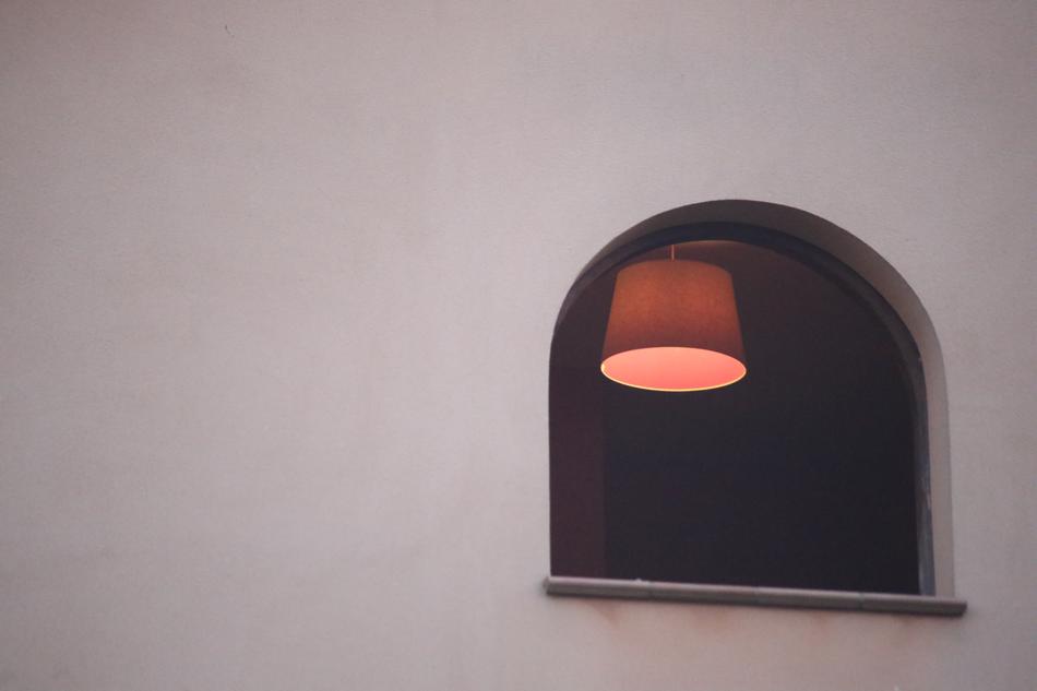 window with a burning lamp in the room