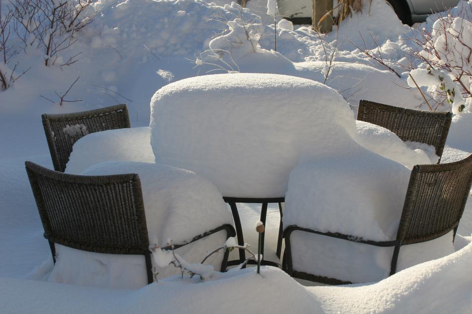 black table and chairs covered with snow