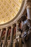bronze statue on the background of columns