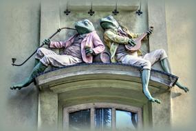 sculpture of frogs on the facade of a house