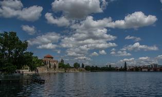 white clouds in the sky over the river