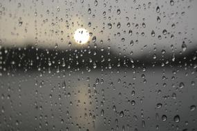 rainy evening, setting sun through Drops Of Water on Window glass