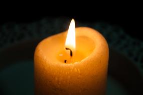 Flame on wick of large wax candle