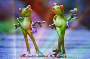 two funny female Frog figurines, blur background