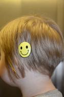 a smiley face barrette on a girl head