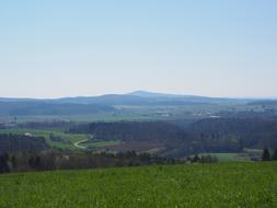 green field under a blue sky