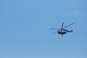 military helicopter in the blue sky