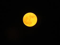 bright yellow moon in a black sky