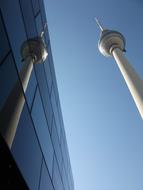 the tall tower is reflected in the glass house