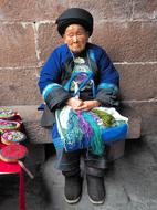 an old lady sitting in front of the building