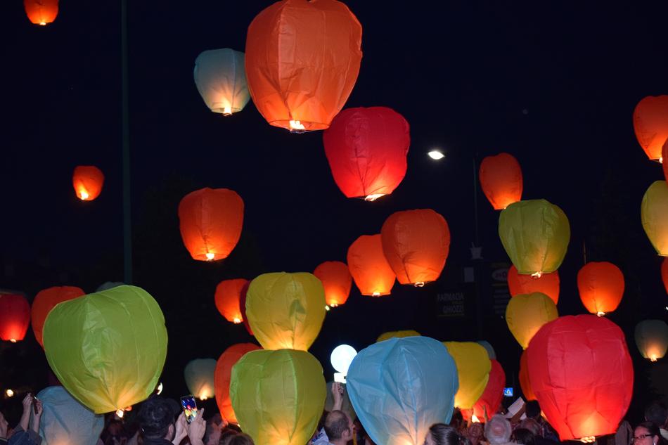 lot of colorful sky lanterns over crowd of people