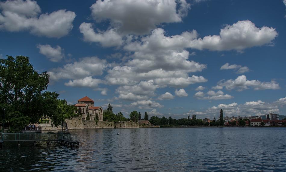 white clouds in the sky over the river